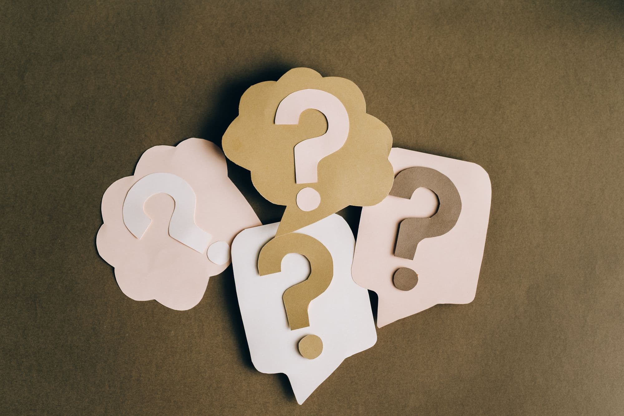 Photo of 4 paper speech bubbles with a question mark inside each one
