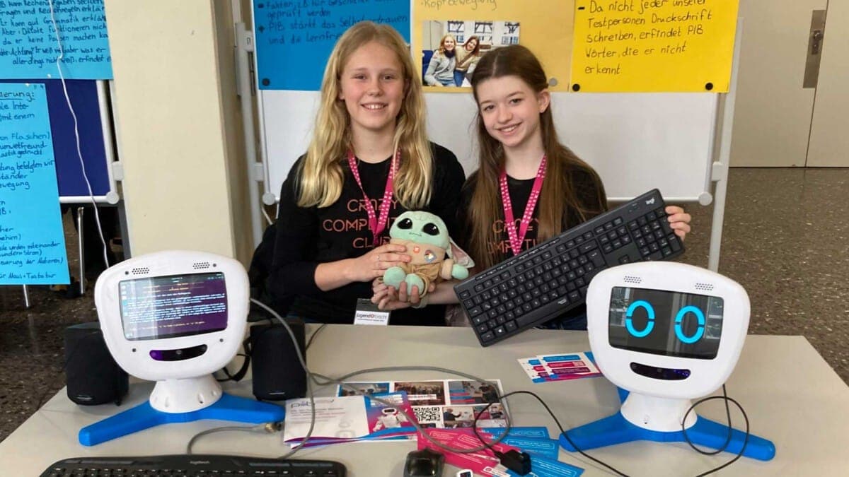 Photo of students with two humanoid robotos